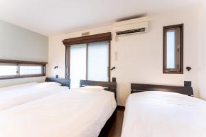 箱根箱寝荘 - Hakoneso的带2扇窗户的客房内的2张床
