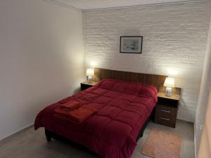 派桑杜Apart del Este 2的一间卧室配有红色的床和2个床头柜