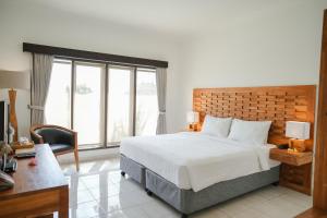 乌鲁瓦图巴厘岛山谷S度假酒店的一间卧室配有一张床、一张书桌和一个窗户。