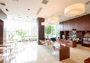 滨松Hotel day by day的大型客房设有桌椅和窗户。