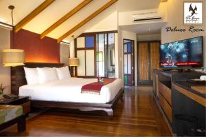清迈德兰纳酒店的一间卧室配有一张床和一台平面电视