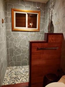 科克莱斯Cabina Harlequin at Margarita Hills Farm的一间带木门和石墙的浴室