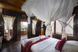 蓝梦岛Mushroom Beach Bungalows的一间卧室配有一张带白色床单和窗帘的床