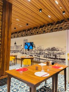 孟买Ginger Mumbai, Goregaon的一间设有桌子和墙上绘图的用餐室