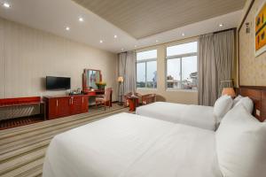 河内Hoa Dao Hotel的酒店客房设有两张床和电视。