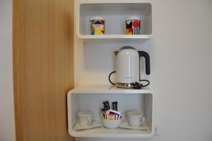 萨格勒布Rooms Indigo Bundek的咖啡壶和架子上的杯子