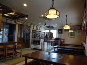 白马村和味亭日式旅馆的餐厅配有桌椅和灯光