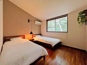 志摩市UMIBE IseShima的一间卧室设有两张床和窗户。