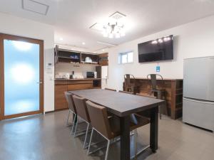 冲绳岛市科扎酒店的厨房以及带桌子和冰箱的用餐室