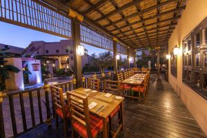 海塞卜阿塔纳穆桑达姆度假酒店的一间在甲板上配有木桌和椅子的餐厅