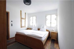 MainleusOchsenhof的一间卧室配有一张带白色床单的床和两个窗户。