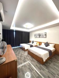 岑山An Cường Hotel的酒店客房配有两张床和风扇