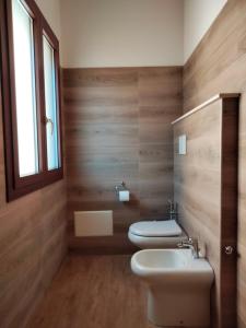 阿尔盖罗Agriturismo i doni del mandorlo的浴室设有2个卫生间、水槽和窗户。