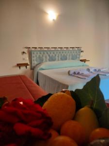 阿尔盖罗Agriturismo i doni del mandorlo的一间卧室配有一张床和一碗水果