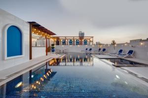 迪拜多纳泰罗酒店的一座带椅子的游泳池以及一座建筑