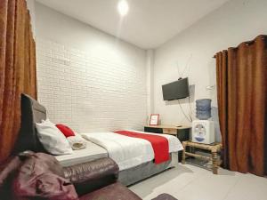 马塔兰RedDoorz Syariah near Siloam Hospital Mataram的一间卧室配有一张床和一台电视。
