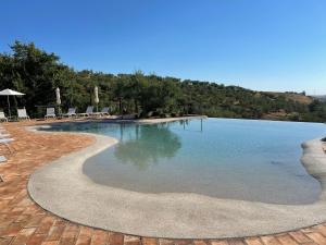 FirmoCastello di Serragiumenta的一个带椅子和水的大型游泳池