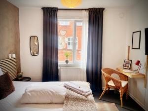 腓特烈西亚加美尔哈富恩酒店的一间卧室配有一张床、一张书桌和一个窗户。
