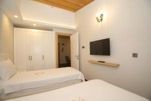 穆拉Raymar Hotels Muğla的一间卧室配有两张床和一台平面电视