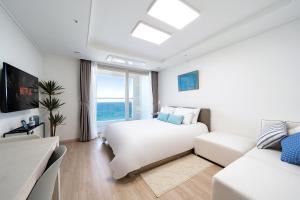 束草市Urbanstay Sokcho Deungdae Beach的白色卧室配有床和沙发