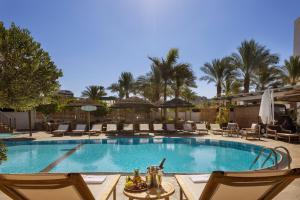 埃拉特Play Eilat Hotel的一个带椅子和桌子的度假村游泳池