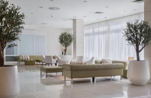 波尔蓝阳埃拉弗萨酒店的大堂配有沙发、椅子和树木
