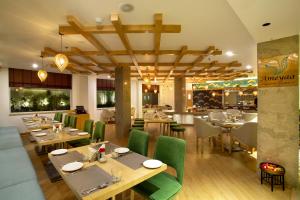 格德拉Ramada by Wyndham Katra Station Road的餐厅设有木桌和绿色椅子