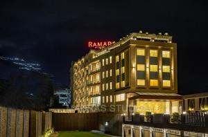 格德拉Ramada by Wyndham Katra Station Road的上面有酒店标志的建筑