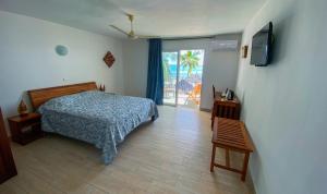 安迪拉纳Orangea Beach Resort的一间卧室配有一张床,墙上配有电视