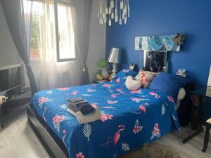 波城ELLO HAPPINESS HOME place to be in pau的蓝色卧室,配有一张带蓝色棉被的床