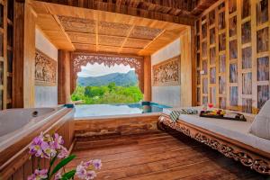 象岛Santhiya Tree Koh Chang Resort的带浴缸的浴室和大窗户