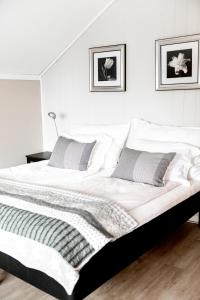 FiskåMoens Motell的卧室配有一张带两个枕头的大白色床