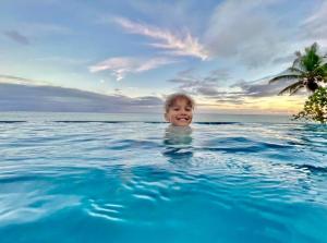 科罗雷乌毛伊岛棕榈酒店的在一个海洋游泳池游泳的男孩