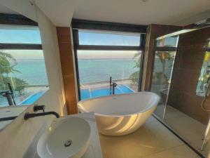 科罗雷乌毛伊岛棕榈酒店的带浴缸和水槽的浴室以及海洋