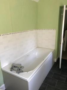 布里德波特The Victorian House的浴室设有白色浴缸,拥有绿色的墙壁