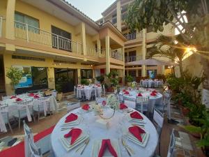 罗安达Afilux Residencial的宴会厅配有白色桌子和红色餐巾