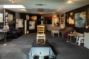 艾姆波茨卡佩尔gîte Artbnb的配有桌椅和绘画的房间