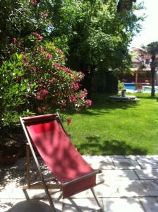 莱齐尼昂科尔比埃卡塔莱住宿加早餐旅馆的坐在庭院里的红色椅子