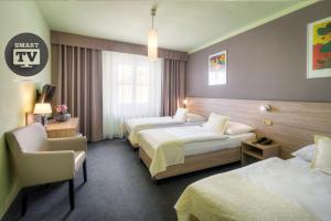 布拉格大西洋酒店的酒店客房,配有两张床和椅子