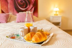 Bourthes特奥斯马奎特斯住宿加早餐酒店的床上的面包和橙汁托盘