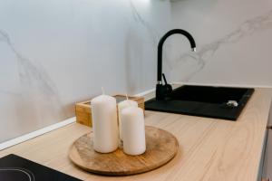 克卢日-纳波卡Evo Residence Migdalului的木桌上的两把白色蜡烛和水槽