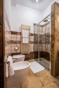 伊格莱西亚斯Il Rifugio dei Minatori的带浴缸、卫生间和淋浴的浴室。