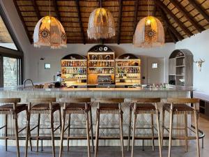 克拉塞利尔自然保护区Simbavati Waterside的一间酒吧,在房间内配有木凳