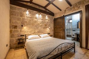 伊格莱西亚斯Il Rifugio dei Minatori的一间卧室设有一张床和石墙