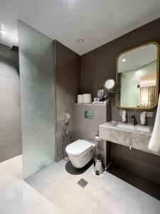 迪拜City Seasons Suites的一间带卫生间、水槽和镜子的浴室