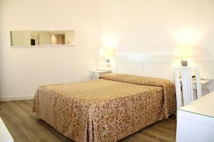 马里纳-迪-皮特拉桑塔滨海酒店的酒店客房,配有床和镜子