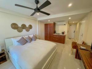 科罗雷乌毛伊岛棕榈酒店的卧室配有白色的床和吊扇