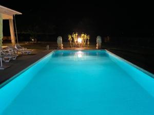 维拉·雷阿尔Quinta da Menina Guest House的夜间大型蓝色游泳池