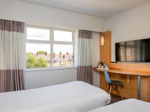 约克宜必思约克中心酒店的配有一张床、一张书桌和一扇窗户的酒店客房