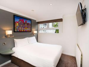切斯特切斯特艾伯特威尔美居酒店的卧室设有一张白色大床和一扇窗户。